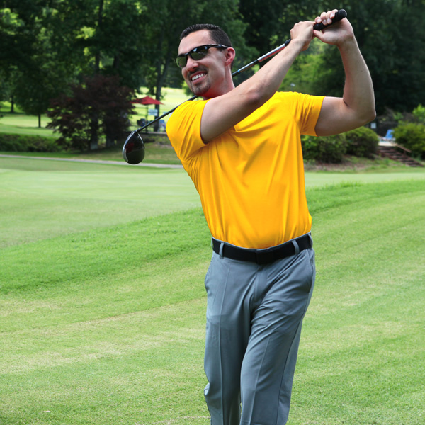 Golfer in yellow shirt who just completed a golf shot